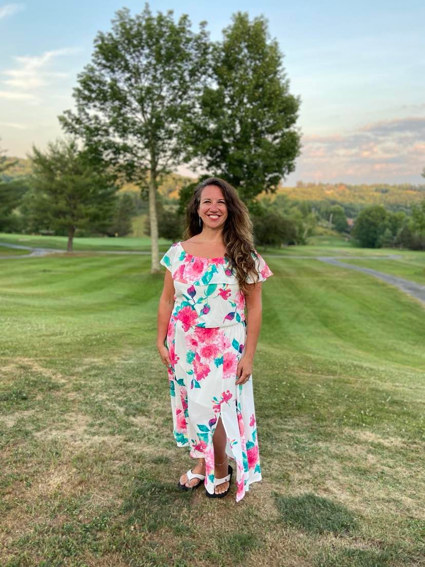Natalie, founder of Empowering Creative Souls, smiling outdoors at golden hour